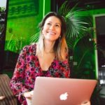 Woman in Red and Black Floral Dress Using Macbook