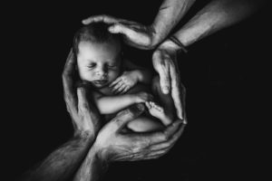 grayscale photo of woman hugging baby